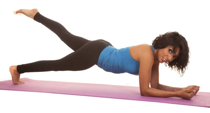 Girl training with leg lift from plank position.